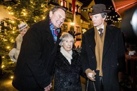Lise Noergaard sammen med Ulf Pilgaard (tv.) og karakteren Mads Skjern fra Matador i Korsbaek paa Bakken torsdag den 22. november 2018. Korsbaek er blevet pyntet smukt og nostalgisk op med julelys, juletraeer og pynt. Julepynten i Algade og i Korsbaeks stuer er specielt udvalgt efter 1930 ernes julepynt i Danmark og med inspiration fra Lise Noergaards fortaellinger om hendes families juletraditioner fra tiden. For foerste gang i Bakkens 435 aar lange historie byder verdens aeldste forlystelsespark velkommen i juletiden. , Klampenborg Denmark  Copyright: NikolaixLinares NikolaixLinaresx COP102 spdk20181122-192049-L