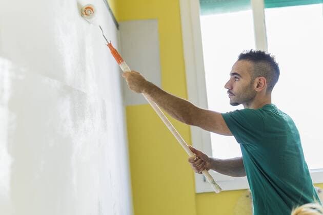 Man painting wall at new home model released Symbolfoto property released  FBAF00036
