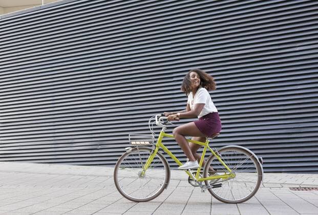 Smiling young woman riding bicycle model released Symbolfoto  JUNF01474