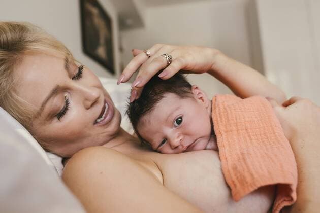 Newborn baby lying skin to skin with mother in bed model released Symbolfoto property released  MFF04590