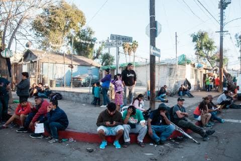 Migrants that are part of the caravan from Central America sit outside of the makeshift migrant shelter at Unidad Deportiva Benito Juarez Stadium on November 26, 2018 in Tijuana, Mexico. Sunday afternoon, some migrants protesting a backlog of asylum claims rushed toward the border and were met with tear gas.  TIJ2018112609 ARIANAxDREHSLER