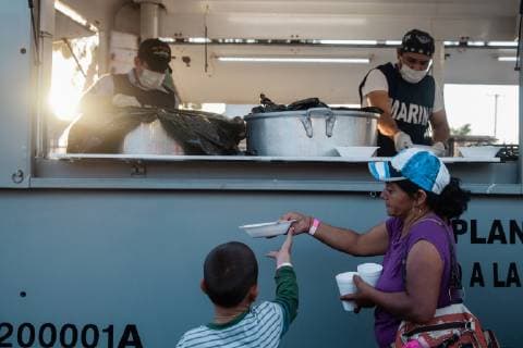 Food is served at the makeshift migrant shelter at Unidad Deportiva Benito Juarez Stadium on November 26, 2018 in Tijuana, Mexico. Sunday afternoon, some migrants protesting a backlog of asylum claims rushed toward the border and were met with tear gas.  TIJ2018112610 ARIANAxDREHSLER