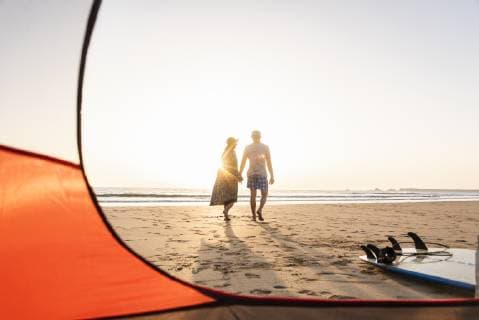 Romantic couple camping on the beach, doing a beach stroll at sunset model released Symbolfoto  UUF15148