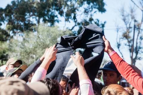 A group of migrants from Central America tug on donated clothing in front of Benito Juarez shelter in Tijuana, Mexico on November 27, 2018. Migrants, refugees and asylum seekers are congregating south of the U.S. border  TIJ2018112715 ARIANAxDREHSLER