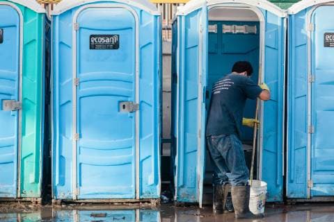 A man cleans the porta-potties at the Benito Juarez shelter in Tijuana, Mexico on November 27, 2018. At present, 5,800 migrants and asylum seekers are staying at the shelter waiting for a chance to enter the U.S.  TIJ20181127210 ARIANAxDREHSLER