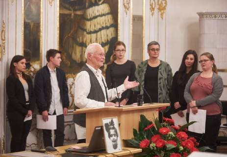 Prizewinner Thilo Pohle at the desk and his film group Rothenburg in the background in front a portrait of Marion Samuel Award Marion Samuel Prize 2018 of the Stiftung Erinnerung an die Dokumentarfilmgruppe Rothenburg ob der Tauber Government of Swabia Rokoko Hall 29 11 2018 Award Marion Samuel Prize 2018 of the Stiftung Erinnerung an die Dokumentarfilmgruppe Rothenburg ob der Tauber B-HAUPT
