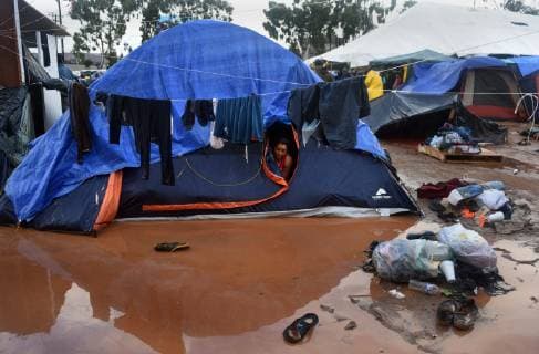 November 29, 2018 - Tijuana, Mexico - People navigate severe flooding at the migrant caravan camp Centro Deportivo Benito Juarez on November 29, 2018. It is being called a humanitarian crisis. IMELDA LIMA LOPEZ and her twins look at dirty water at their tent. SAIRA MAVEC MEZA, 5 years old, developed a rash from the tear gas said her mother. They were the focus of an image by Reuters photojournalist Kim Kyung-Hoon taken as they ran from tear gas fired by U.S. agents during chaos at the border on Sunday. The photo went viral. She came from Honduras with five children. She has nine total, 3 still in Honduras and 1 in Louisiana. We lost everything, said a migrant walking through debris. Many migrants appeared to realize that the hope they held to begin a new life in America had dimmed and their stay in Mexico may be longer than anticip - ZUMAg208 20181129_zap_g208_012 Copyright: xCarolxGuzyx