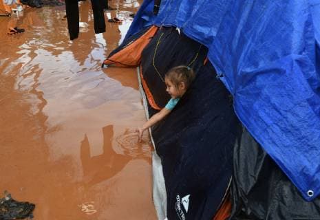 November 29, 2018 - Tijuana, Mexico - People navigate severe flooding at the migrant caravan camp Centro Deportivo Benito Juarez on November 29, 2018. It is being called a humanitarian crisis. IMELDA LIMA LOPEZ and her twins look at dirty water at their tent. SAIRA MAVEC MEZA, 5 years old, developed a rash from the tear gas said her mother. They were the focus of an image by Reuters photojournalist Kim Kyung-Hoon taken as they ran from tear gas fired by U.S. agents during chaos at the border on Sunday. The photo went viral. She came from Honduras with five children. She has nine total, 3 still in Honduras and 1 in Louisiana. We lost everything, said a migrant walking through debris. Many migrants appeared to realize that the hope they held to begin a new life in America had dimmed and their stay in Mexico may be longer than anticip - ZUMAg208 20181129_zap_g208_019 Copyright: xCarolxGuzyx