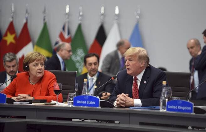 December 1, 2018 - Buenos Aires, Argentina - U.S. President Donald Trump, right, address the plenary session on Day Two of the G20 Summit meeting as German Chancellor Angela Merkel, left, looks on at the Costa Salguero Center December 1, 2018 in Buenos Aires, Argentina. Buenos Aires Argentina - ZUMAp138 20181201_zaa_p138_049 Copyright: xG20xArgentinax