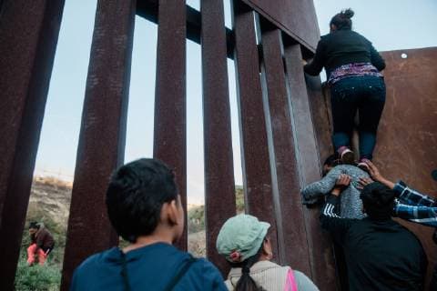 Migrants climb over the border fence that divides the United States and Mexico on December 2, 2018 near Las Playas de Tijuana, Mexico.  TJ2018120206 ARIANAxDREHSLER