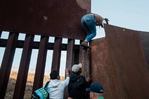 With growing frustration at the length of the asylum process, migrants climb over the border fence that divides the United States and Mexico on December 2, 2018 near Las Playas de Tijuana, Mexico.  TJ20181202204 ARIANAxDREHSLER