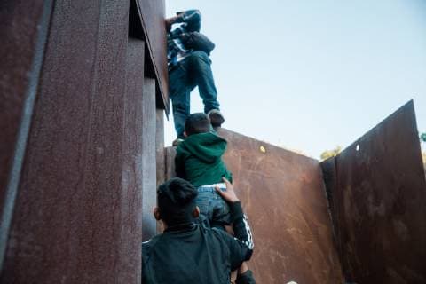 Migrants climb over the border fence that divides the United States and Mexico on December 2, 2018 near Las Playas de Tijuana, Mexico.  TJ20181202207 ARIANAxDREHSLER