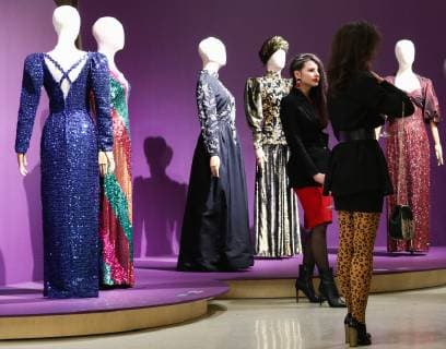 MOSCOW, RUSSIA - DECEMBER 4, 2018: Girlsl seen by dresses on display at an exhibition titled The Glamour of the 80s by Russian fashion historian Alexandre Vassiliev opened at the VDNKh exhibition centre. The exhibition shows a unique collection of the 1980s costumes by Chanel, Christian Dior, Yves Saint Laurent, Givenchy, Pierre Balmain, Claude Montana, and other fashion houses. Mikhail Tereshchenko TASS  TS099CBE