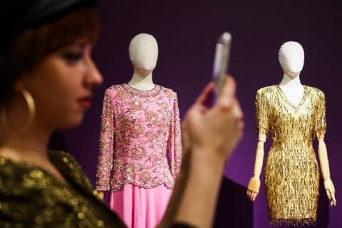 MOSCOW, RUSSIA - DECEMBER 4, 2018: A girl seen by dresses on display at an exhibition titled The Glamour of the 80s by Russian fashion historian Alexandre Vassiliev opened at the VDNKh exhibition centre. The exhibition shows a unique collection of the 1980s costumes by Chanel, Christian Dior, Yves Saint Laurent, Givenchy, Pierre Balmain, Claude Montana, and other fashion houses. Mikhail Tereshchenko TASS  TS099CC1