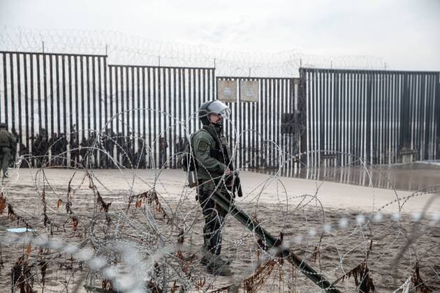 A border patrol agent stands near the border fence that divides the United States and Mexico at Border Field State Park in San Diego, California on December 10, 2018.  SDP2018121045 ARIANAxDREHSLER