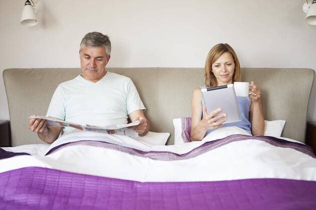  Couple Relaxing In Bed With Newspaper And Digital Tablet model released Symbolfoto property released  Copyright: xMonkeybusinessx Panthermedia19366174