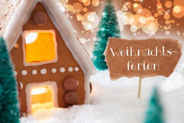  Gingerbread House In Snowy Scenery As Christmas Decoration. Christmas Trees And Candlelight. Bronze And Orange Background With Bokeh Effect. German Text Frohe Weihnachten Means Merry Christmas  Copyright: xNelosax Panthermedia19538920