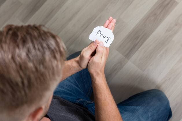  Piece Of Paper With Text Pray In Man s Hand model released Symbolfoto  Copyright: xAndreyPopovx Panthermedia20211163