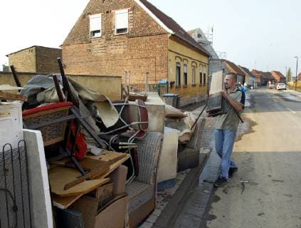 A man carrys furniture from his flooded house in the village Seegrehna near Wittenberg eastern Germany Tuesday Aug 27 2002 The swollen Elbe river floods this village in Saxony Anhalt last week Eckehard Schulz SEEGREHNA DEU