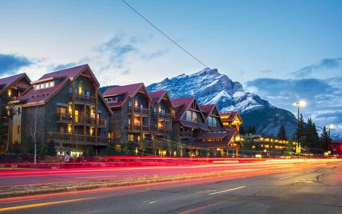 Trail lights on Banff Avenue and mountains in background at dusk, Banff, Banff National Park, Alberta, Canada, North America Copyright: TomsxAuzins 1276-530