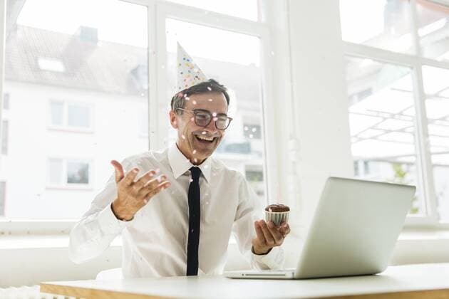 Geburtstag - Symbolbilder Laughing businessman with laptop celebrating birthday in office model released Symbolfoto property released  MOEF01461