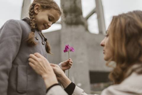 Little girl watching mother s hands buttoning her coat model released Symbolfoto  KMKF00061