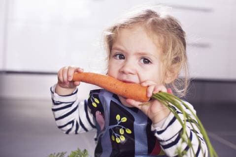 Little girl eating a carrot  Copyright: Anne-SophiexBost B33608439
