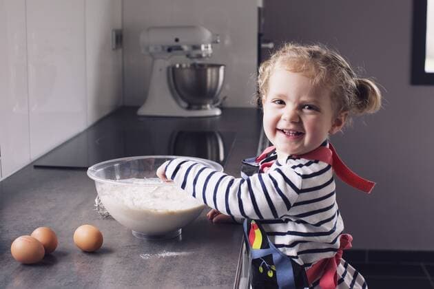 Little girl mixing batter, smiling, portrait  Copyright: Anne-SophiexBost B38906439