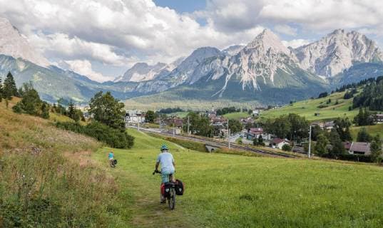 cyclist on cycle tour with mountain bike on the cycle path Via Claudia Augusta rear Ehrwalder Sonnenspitze alpine crossing mountain landscape Alps Ehrwalder Becken near Ehrwald Tyrol Austria Europe Copyright: imageBROKER/MoritzxWolf ibxmmw04807947.jpg