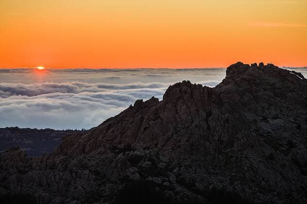 Panoramic view at sunset over rocks to a sea of clouds over the Sardinian Gallura Punta Balestrieri Monte Limbara Tempio Pausania Sardinia Italy Evening light on Monte Limbara