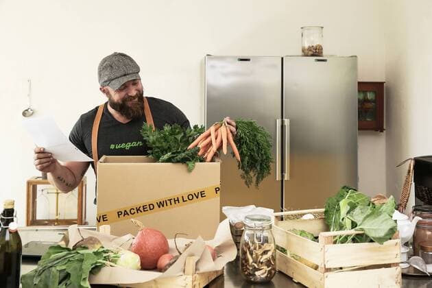 Mature man with delivery service packing organic vegetables in cardboard model released Symbolfoto property released  REAF00367