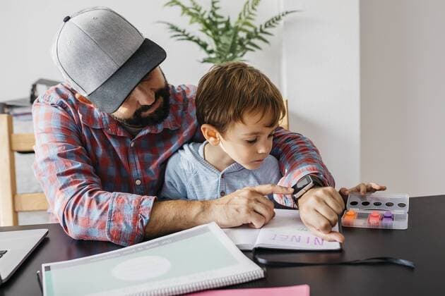 Father texplaining his son the smartwatch, while working at home model released Symbolfoto property released  JRFF01998