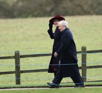 The lady with Sir Jackie Stewart holds on to her hat in the windy conditions after they joined HM Queen Elizabeth II as she attended the St. Mary Magdalene Church Sunday morning service, in Sandringham, Norfolk, on January 27, 2019. 