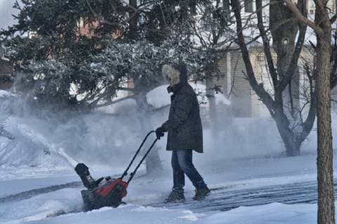 January 27, 2019 - Toronto, ONTARIO, Canada - Homeowner uses a snow-blower to clear snow from his driveway as strong winds caused blowing snow that wreaked havoc across the Greater Toronto Area on January 27, 2019. Toronto Canada  - ZUMAn230 20190127_zaa_n230_432 Copyright: xCreativexTouchxImagingxLtdx