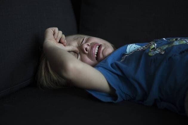 Crying boy lying on couch model released Symbolfoto  JLOF00295