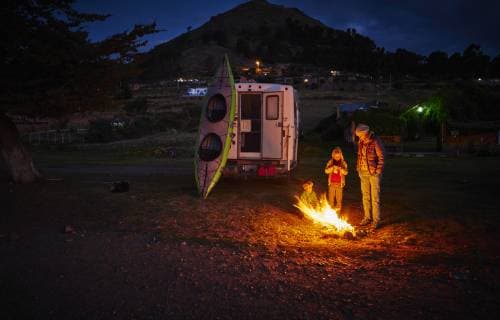 IMAGO Creative: Herbst, Touren mit dem Camper Bolivia, Copacabana, mother with sons standing at camp fire at camper at night model released Symbolfoto property released  SSCF00044