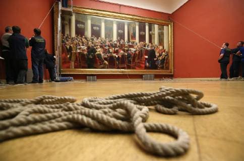 ST PETERSBURG, RUSSIA - FEBRUARY 11, 2019: Russian Museum workers take a painting by Ilya Repin, Ceremonial meeting of the State Council of 7 May 1901 on the day of the Centenary of its Establishment , off its stretcher in Mikhailovsky Castle (St Michael s Castle) as it is prepared to be shipped to Moscow for a Tretyakov Gallery exhibition marking Ilya Repin s 175th birthday anniversary. Peter Kovalev TASS  TS0A0902
