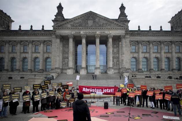 Aktion gegen Waffenhandel DEU, Deutschland, Germany, Berlin, 26.02.2019 Demonstranten mit Plakat Stoppt den Waffenhandel der Kampagne der Aktion - Stoppt den Waffenhandel, Aufschrei Gegen den Export von Terror und Gewalt made in Germany - unter dem Motto Ruestungsexporte stoppen Den Frieden Stark Machen fordern im Rahmen einer politischen Kampagne ein Verbot des deutschen Waffenhandels vor dem Reichstag, Deutscher Bundestag in Berlin. Deutschland ist drittgroesster Waffenexporteur der Welt. Aktion der Friedensbewegung gegen Exporte von Waffen und Ruestungsexporte nach Saudi-Arabien. Protest of the peace movement against the export of wappons under the slogan Action Outcry - Stop the arms trade in front of the Reichstag, the German Parliament, in Berlin, Germany. Demonstrators protest against arms exports in front of the German Bundestag o