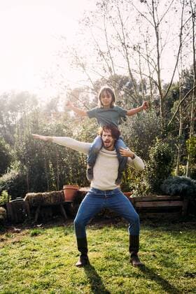 Father playing with his son, carrying him piggyback in a garden model released Symbolfoto property released  GEMF02716