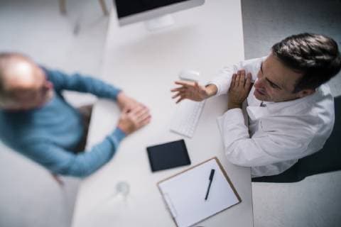Top view of doctor talking to senior patient in medical practice model released Symbolfoto property released  JOSF02779