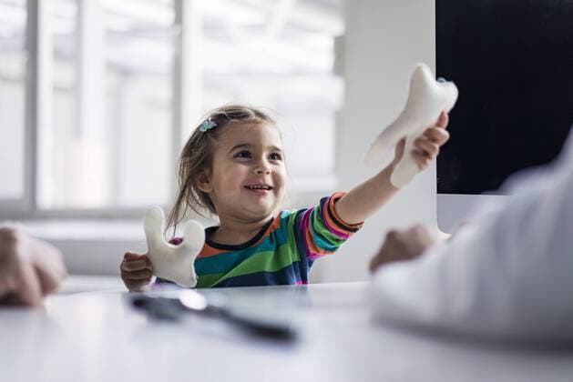 Portrait of smiling girl with tooth model at desk in medical practice model released Symbolfoto property released  JOSF02836