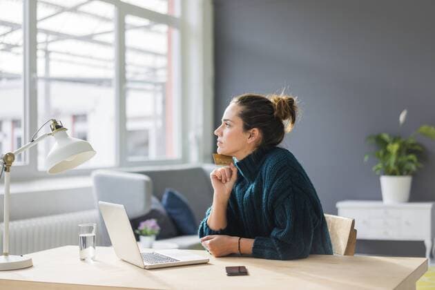 Profile of pensive woman with laptop and credit card sitting at desk at home looking out of window model released Symbolfoto property released  MOEF01854