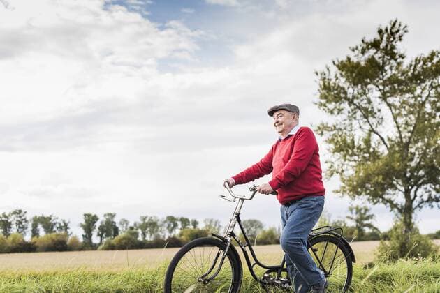 Senior man pushing bicycle in rural landscape model released Symbolfoto  UUF12017