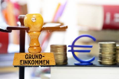 FOTOMONTAGE Stamp with the inscription Basic income ** NUR FUER REDAKTIONELLE ZWECKE ** EDITORIAL USE ONLY **