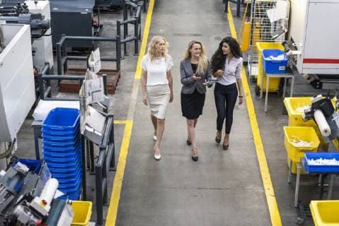 Three women with tablet walking and talking in factory shop floor model released Symbolfoto property released  DIGF05291