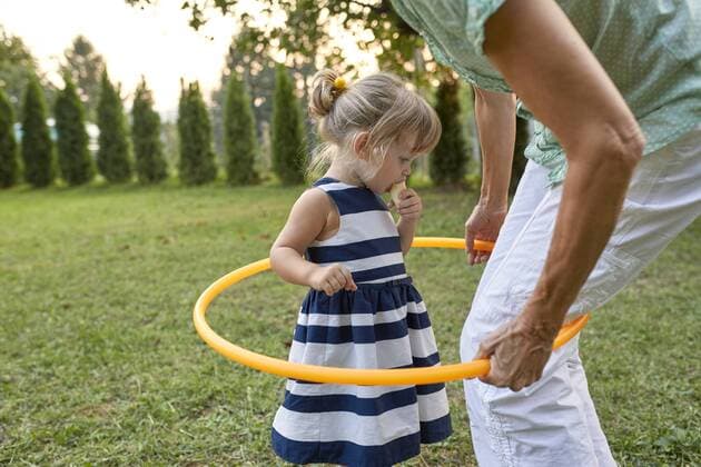 Grandmother and granddaughter playing together in garden with hoola hoop model released Symbolfoto property released  ZEDF01682