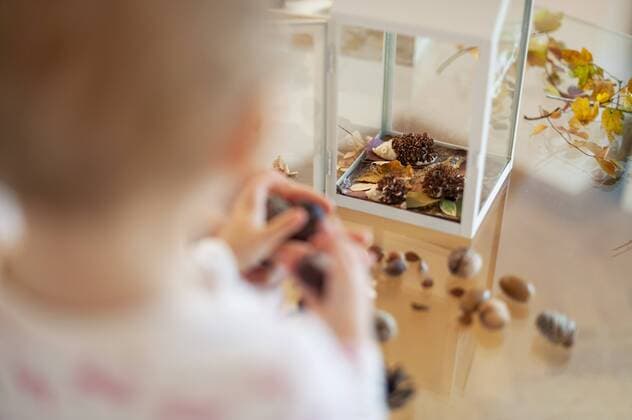 Close-up of little girl tinkering autumnal decorative house at home model released Symbolfoto property released  DIGF05578