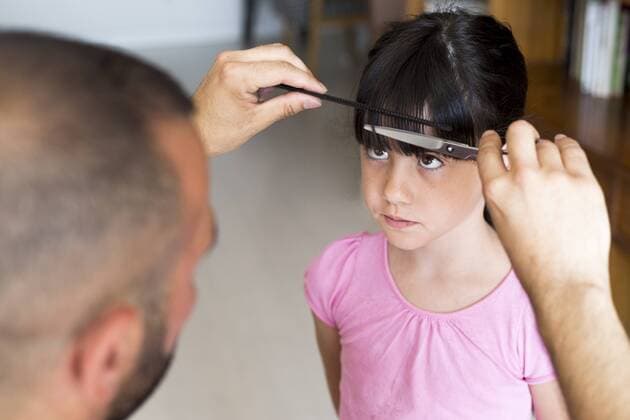 Father cutting daughter s hair at home model released Symbolfoto property released  ERRF00315