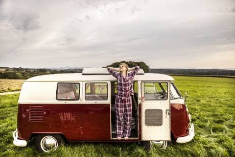 Woman in pyjama stretching in a van in rural landscape model released Symbolfoto property released  FMKF04598