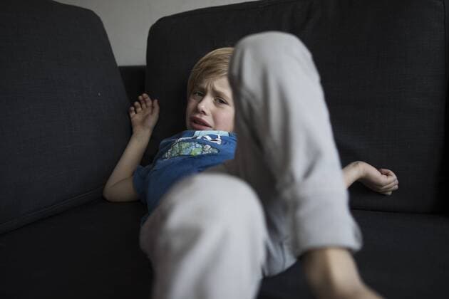 Portrait of sad boy lying on couch model released Symbolfoto  JLOF00294